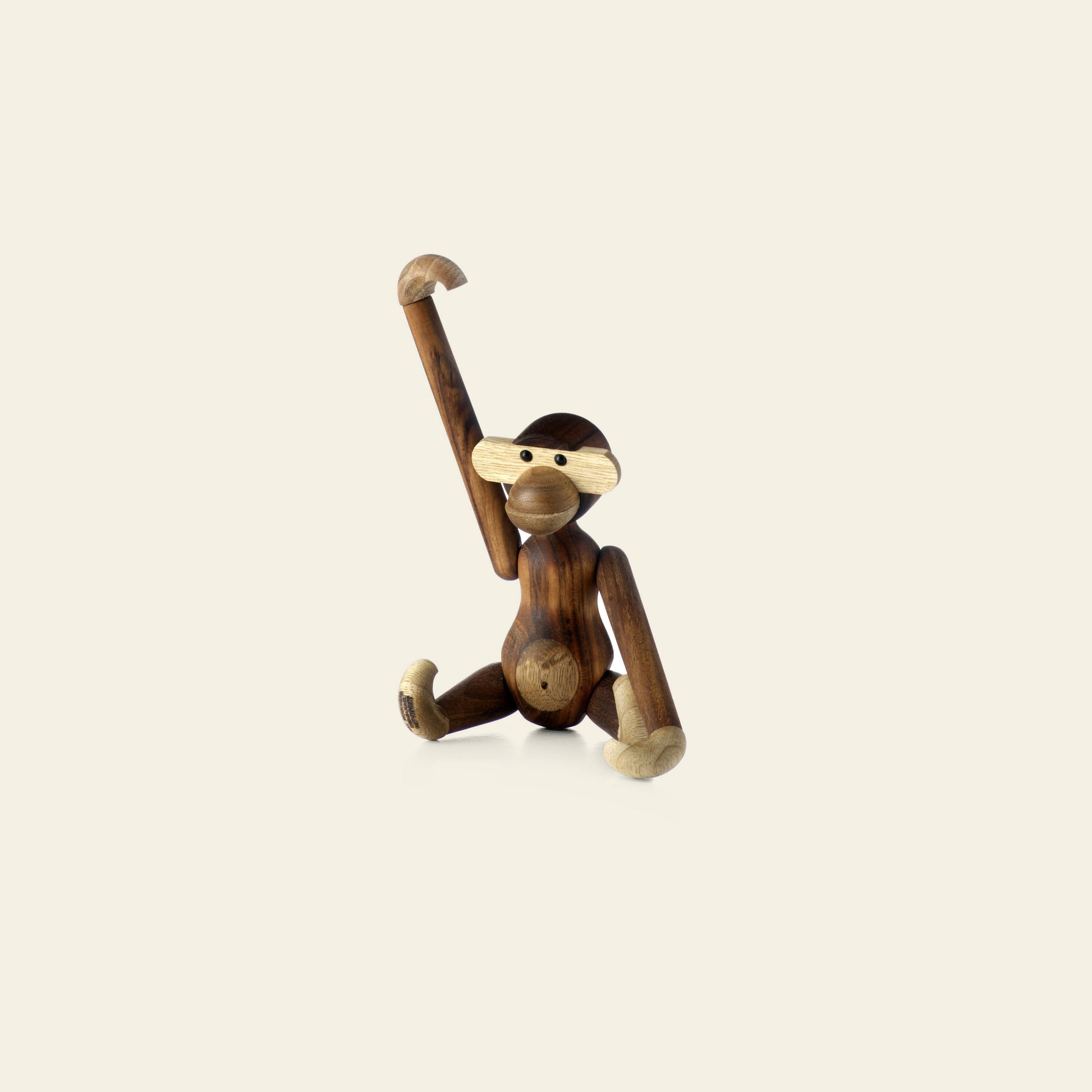 A design icon, the Kay Bojesen Monkey Small by Kay Bojesen features movable limbs and contrasting light and dark wood tones, posed with one arm raised and one leg extended against a plain background—a truly timeless piece.