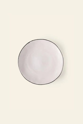 The Kra Sanctuary Andaman Free-Form Dinner Plate features a classic white ceramic glaze, a handmade organic shape, and a slim dark rim—embodying relaxed island living in the signature style of Kra Sanctuary.