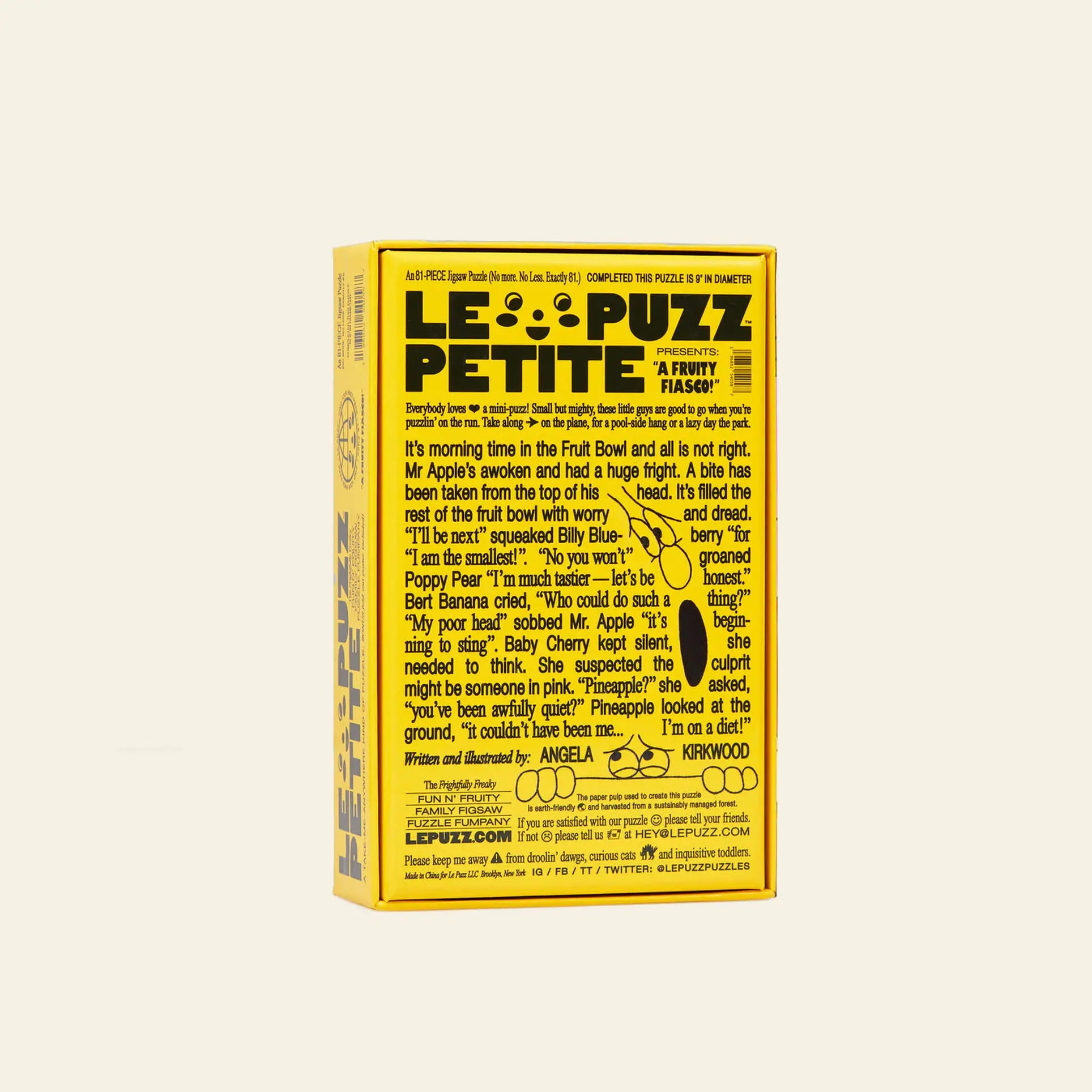 A yellow rectangular Le Puzz A Fruity Fiasco box features playful black text with fruit-themed stories and puzzle details. The sides and back are filled with whimsical writing and cartoon graphics.