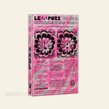 The Le Puzz Freaky Deaky 500 Piece Puzzle comes in a rectangular upright box with bold LE PUZZ branding, vibrant pink, black, and white colors, and abstract flower art by a marbling artist.