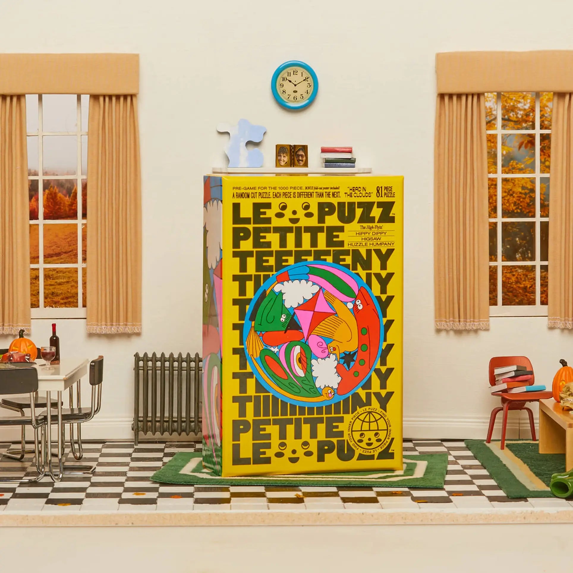 The Le Puzz Head in the Clouds 81 Piece Puzzle by Le Puzz sits center stage in a retro room with checkered floors, beige curtains, whimsical Halloween décor, a clock, books, and bright autumn trees creating an imaginative scene.