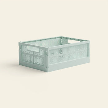 The Made Crate Midi by Made Crate is a light green, rectangular storage crate with perforated sides and built-in handles, crafted from recycled plastic for stackable convenience, shown on a plain off-white background.