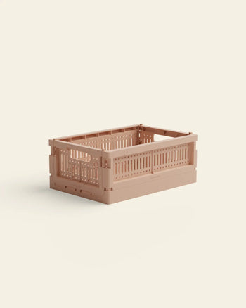 The Made Crate Mini by Made Crate is a light brown, rectangular storage crate with slotted sides and an open top, crafted from recycled plastic for eco-friendly stacking, shown on a light cream background.