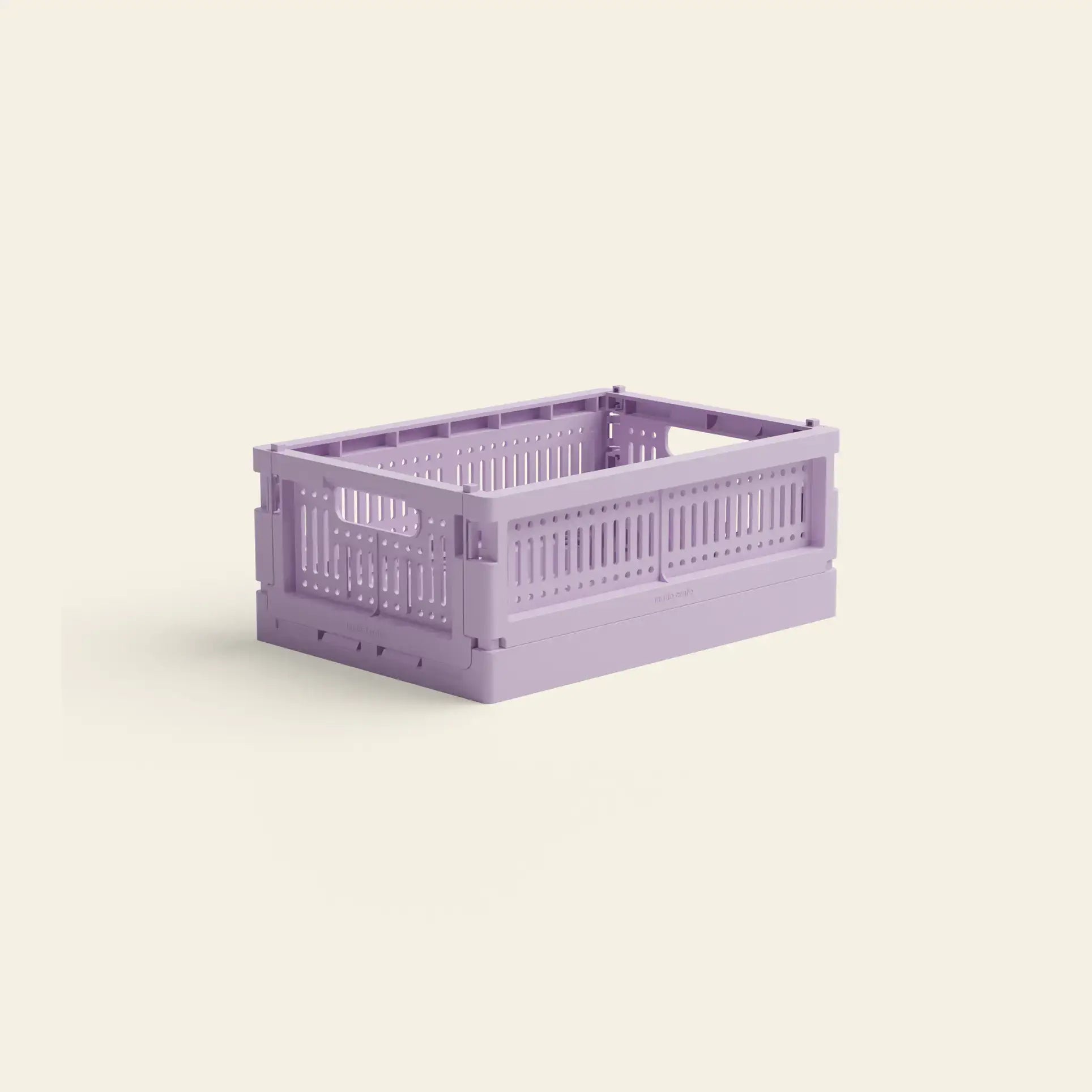 The Made Crate Mini by Made Crate is a light purple, rectangular, eco-friendly folding crate made from recycled plastic with ventilated sides and a minimalist design, shown on a plain beige background for stacking convenience.