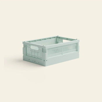 The Made Crate Mini by Made Crate is a light green, rectangular eco-friendly folding crate with ventilated sides and handles, crafted from recycled plastic, displayed on a plain light beige background.