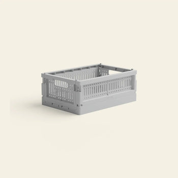 The Made Crate Mini by Made Crate is a light gray, rectangular crate with handles, crafted from recycled plastic for eco-friendly storage, shown on an off-white background.