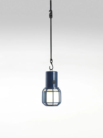The Marset Chispa Portable Table Lamp by Marset, shown against a plain white background, features an industrial-inspired design with a metal cage, black cord, and versatile style ideal for both indoor and outdoor lighting.