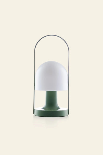 The Marset FollowMe Portable Table Lamp by Marset features a green base, dome-shaped white shade, and a sleek metal handle arching above, shown against a plain beige background.