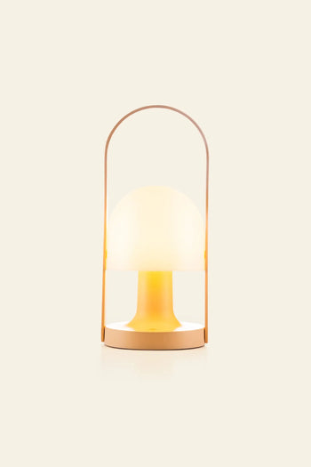 The Marset FollowMe Portable Table Lamp by Marset features a dome-shaped frosted glass shade, warm yellow glow, tan circular base, and matching oak handle, shown against an off-white background.