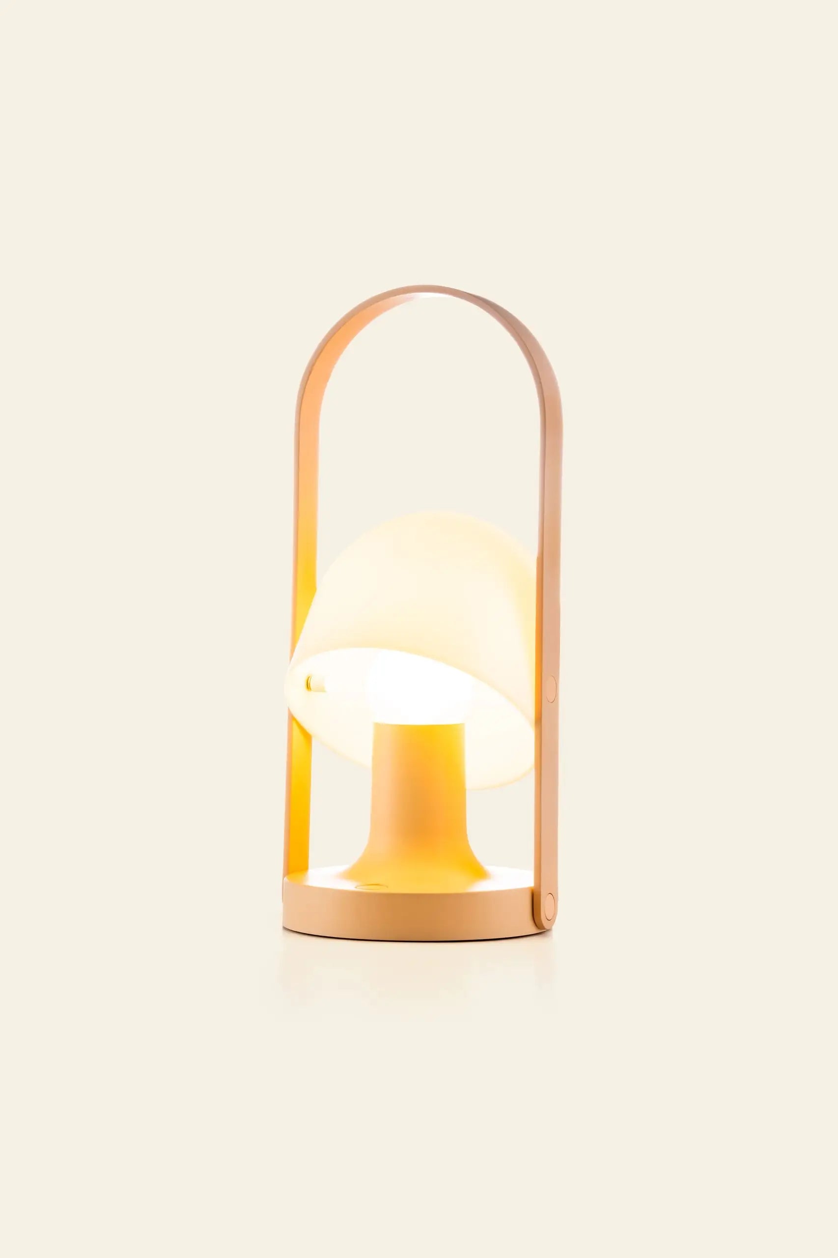 The Marset FollowMe Portable Table Lamp by Marset features a rounded, mushroom-shaped shade, warm rechargeable light, and a curved oak handle in soft beige, set against a plain light background.
