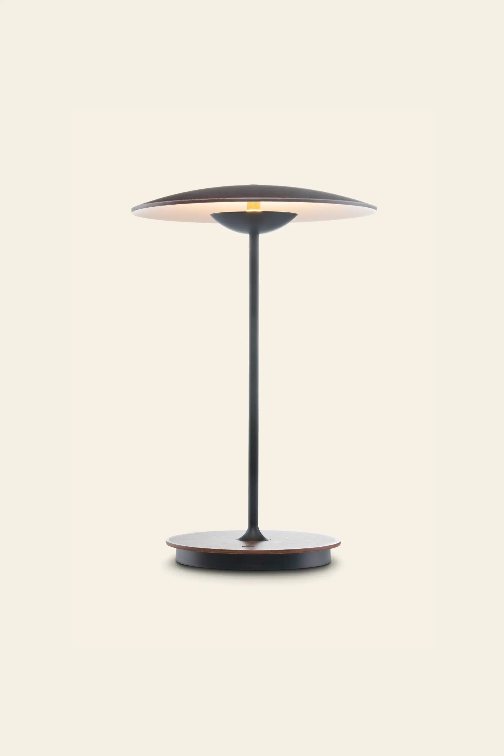 The Marset Ginger 20 M Table Lamp by Marset features a slim stem, circular base, and wide black and brown shade—ideal for bringing a cosy touch to modern decor against light backgrounds.