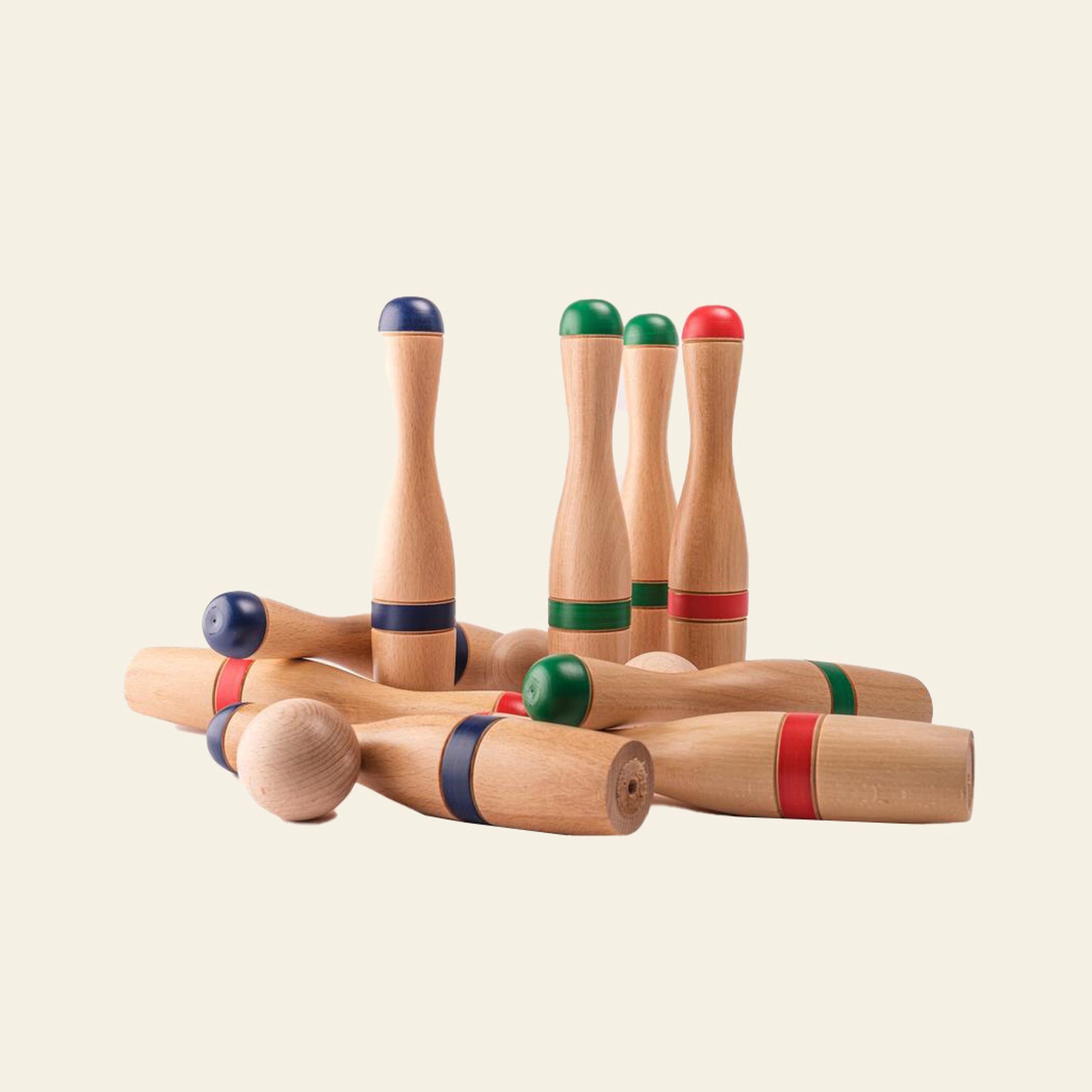 The Mora Play Bowling Pins 24cm Set of 6 by Mora Play features wooden pins with red, green, and blue bands. Some pins are upright while others lie down on a plain, light background.