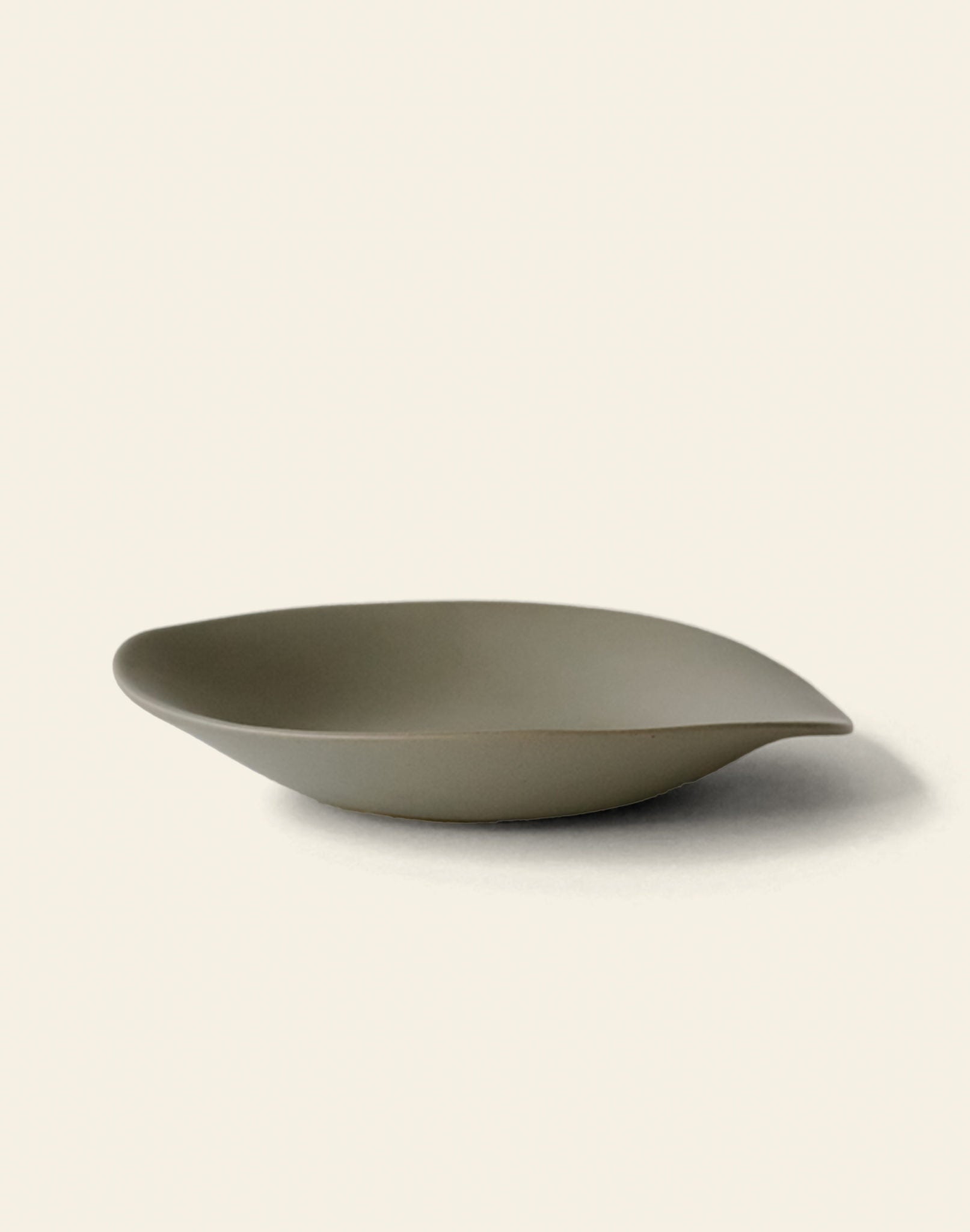The NR Ceramics HIN Dessert Plate features a matte olive-green finish and organic, asymmetrical design—an elegant statement piece from NR Ceramics, shown here on a simple light background.