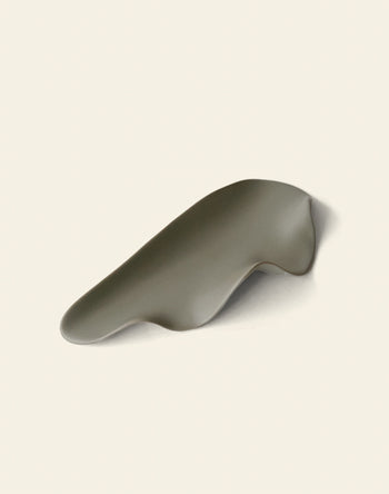 The NR Ceramics HIN Leaf Plate is a smooth gray ceramic dish with gentle curves, offering multi-functional tableware from NR Ceramics, elegantly displayed on a light off-white background.