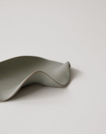 A minimalist photo of the NR Ceramics HIN Leaf Plate by NR Ceramics on a plain white background, featuring soft lighting and smooth curves for a modern look—ideal as versatile multi-functional tableware.