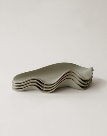 A set of five NR Ceramics HIN Leaf Plates with modern, minimalist design and wavy edges, arranged neatly on a light surface—ideal as versatile tableware for any occasion.