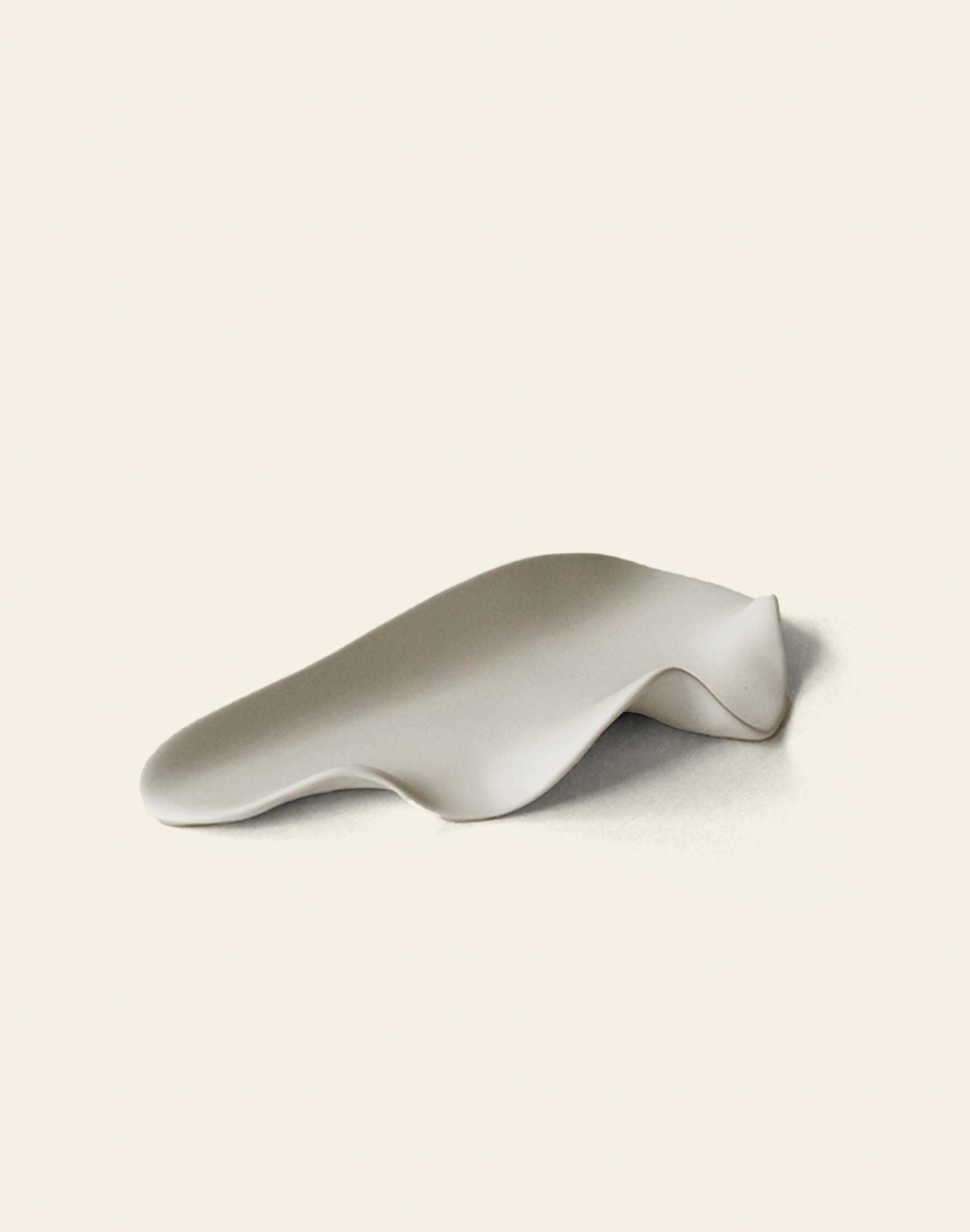 The NR Ceramics HIN Leaf Plate by NR Ceramics is a smooth, white ceramic piece with gentle curves and an abstract, undulating shape, offering a multi-functional design that elevates modern tableware on any setting.
