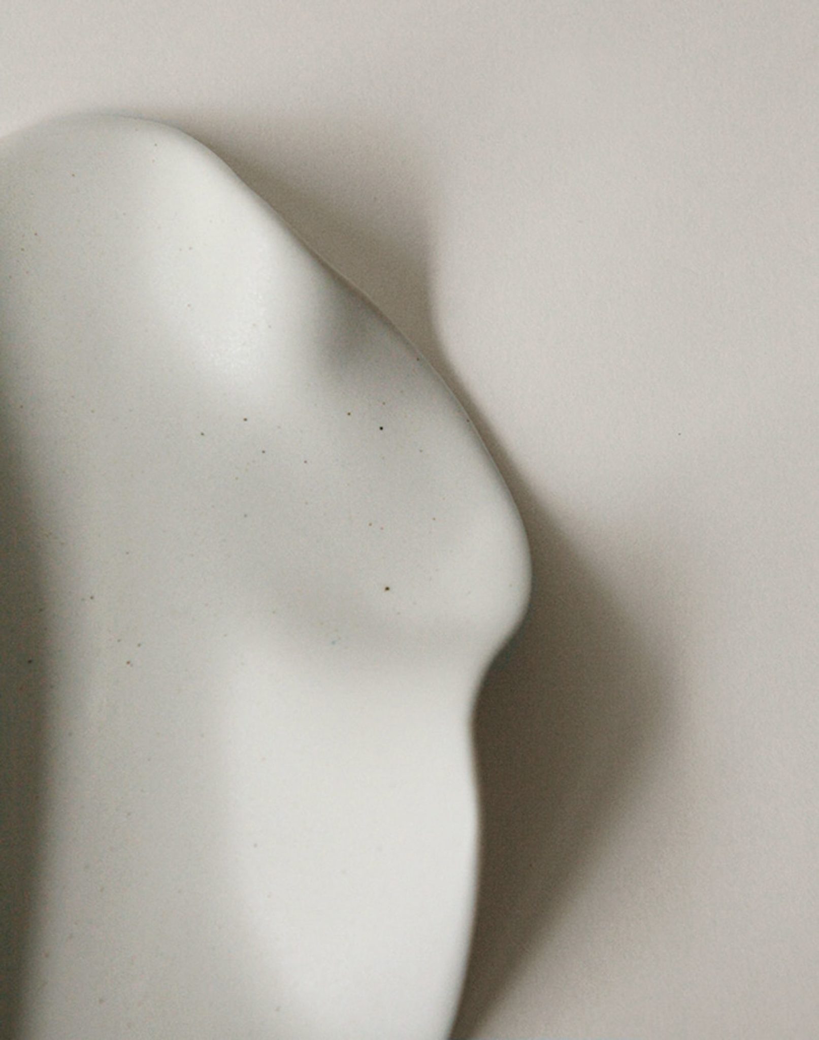 The NR Ceramics HIN Leaf Plate, by NR Ceramics, is a smooth, white ceramic piece with gentle curves and soft shadows on a light surface, echoing the organic elegance of abstract sculpture and multi-functional tableware.