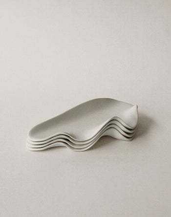Five NR Ceramics HIN Leaf Plates with smooth, wavy edges are stacked neatly, highlighting this elegant, multi-functional tableware set from NR Ceramics against a plain white background.