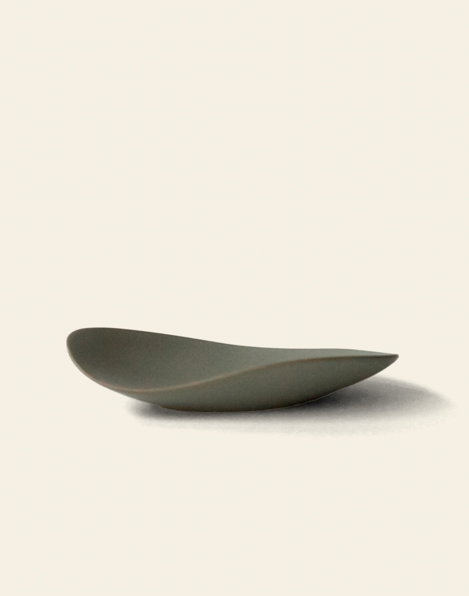 The NR Ceramics HIN Pebble Plate S features a minimalist, shallow design in matte gray with smooth, curved edges—an elegant addition to contemporary tableware, shown on a plain off-white background.