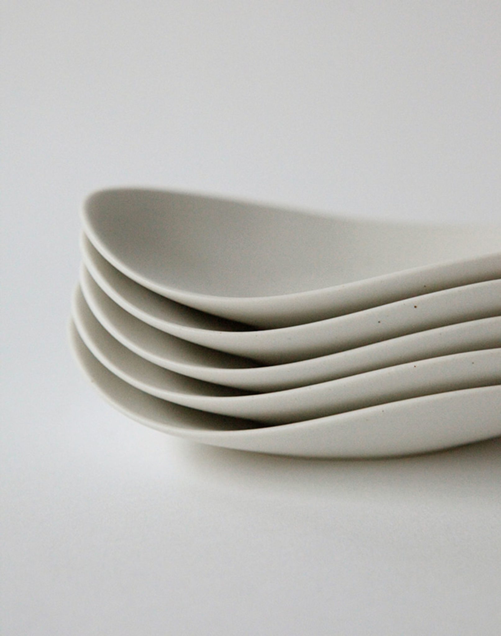 A close-up of the NR Ceramics HIN Pebble Plate S, elegantly displayed on a smooth, neutral background—an ideal piece from NR Ceramics to elevate your tableware collection.