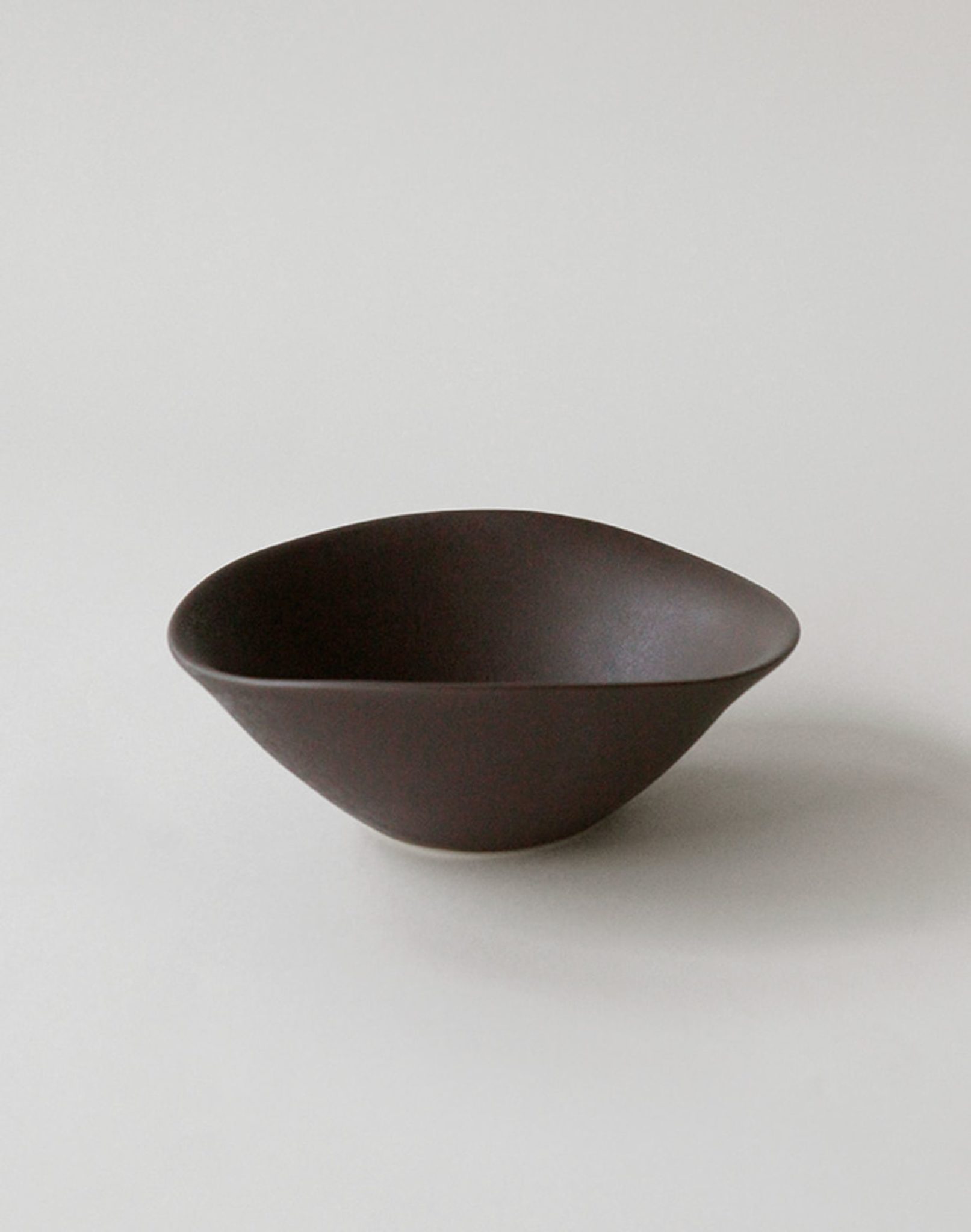 The NR Ceramics HIN Soup Bowl by NR Ceramics features smooth, curved edges and a dark brown finish, making it versatile tableware suited to any setting. Shown here on a plain light background.