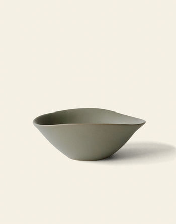 The NR Ceramics HIN Soup Bowl by NR Ceramics features a simple matte olive-green finish, an organic uneven shape, and is perfect as versatile tableware for everyday dining.