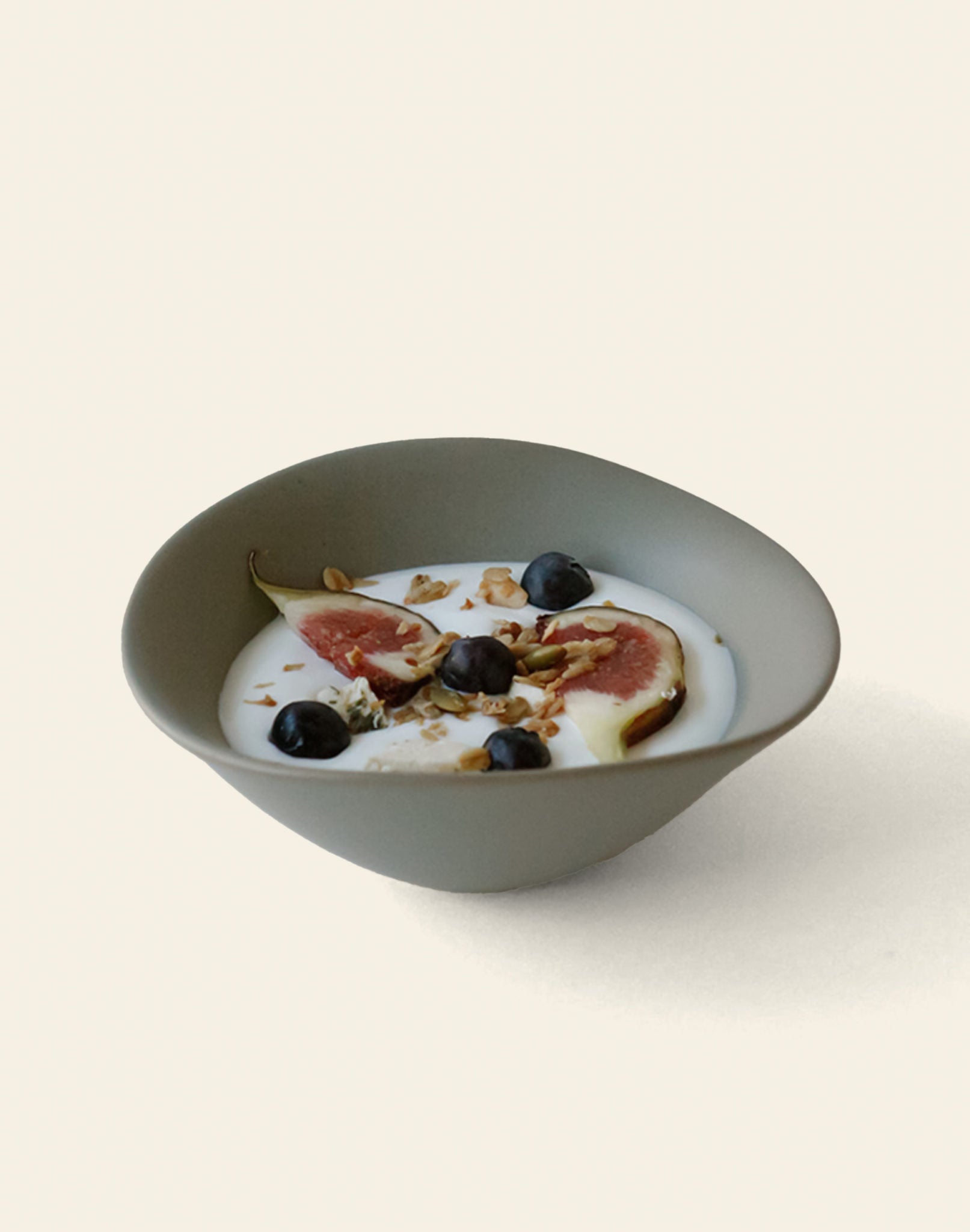 The NR Ceramics HIN Soup Bowl by NR Ceramics, ideal as versatile tableware, holds yogurt with fig slices, blueberries, and granola, displayed against a simple light background.