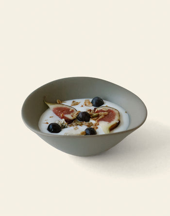 The NR Ceramics HIN Soup Bowl by NR Ceramics, ideal as versatile tableware, holds yogurt with fig slices, blueberries, and granola, displayed against a simple light background.