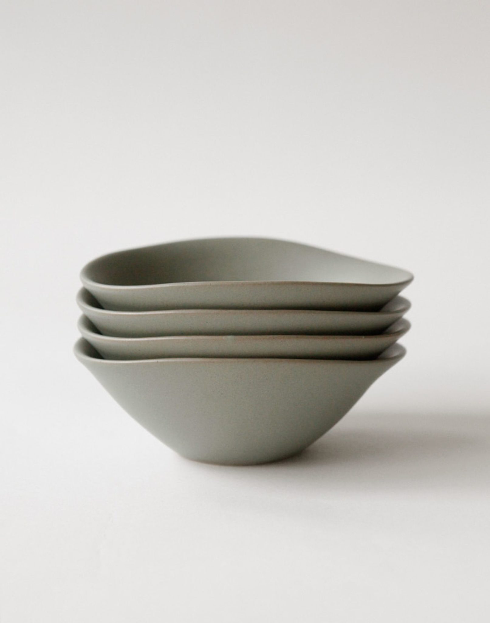 A stack of four NR Ceramics HIN Soup Bowls, featuring minimalist matte grey ceramic and smooth, subtly irregular edges, shown on a plain white background—stylish and versatile tableware by NR Ceramics for everyday meals.