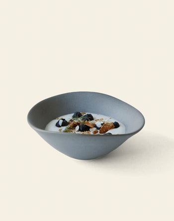 The NR Ceramics HIN Soup Bowl by NR Ceramics, shown in gray and filled with yogurt, blueberries, almonds, and seeds against a plain background, highlights its versatility as tableware for any occasion.