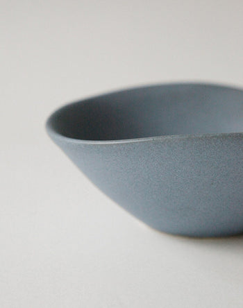 A close-up of the NR Ceramics HIN Soup Bowl, a minimalist blue ceramic bowl with a matte finish and smooth, curved edges by NR Ceramics—an ideal, versatile tableware piece for any setting.
