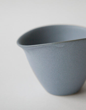 A close-up of the NR Ceramics HIN Tea Cup in matte light blue, featuring a smooth curved rim and ergonomic design, by NR Ceramics, set against a plain light background.