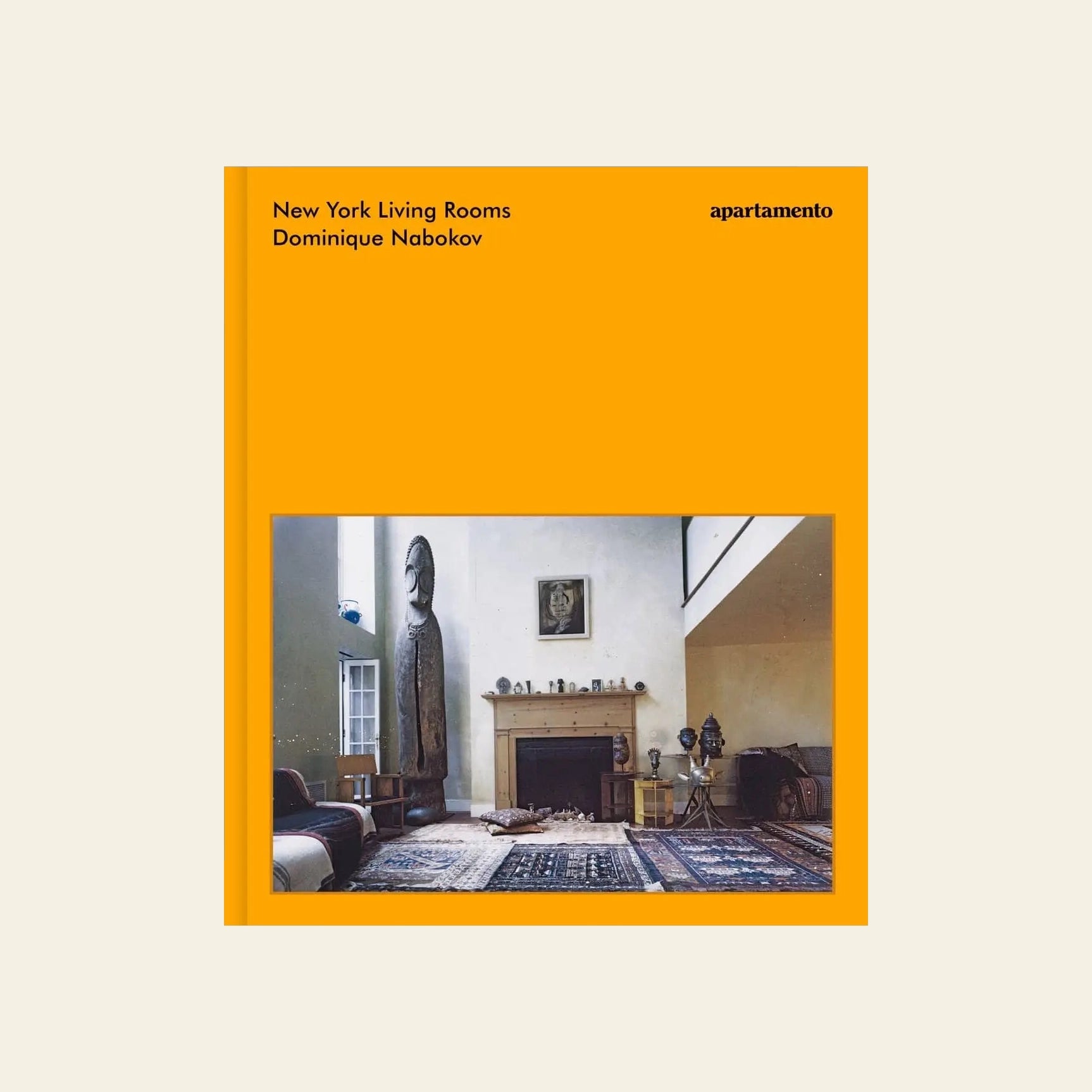 The cover of Apartamento New York Living Rooms by Dominique Nabokov features her iconic interior photo—a chic living room with a fireplace, rug, armchair, and artwork—framed by a vivid orange border and bold black text.
