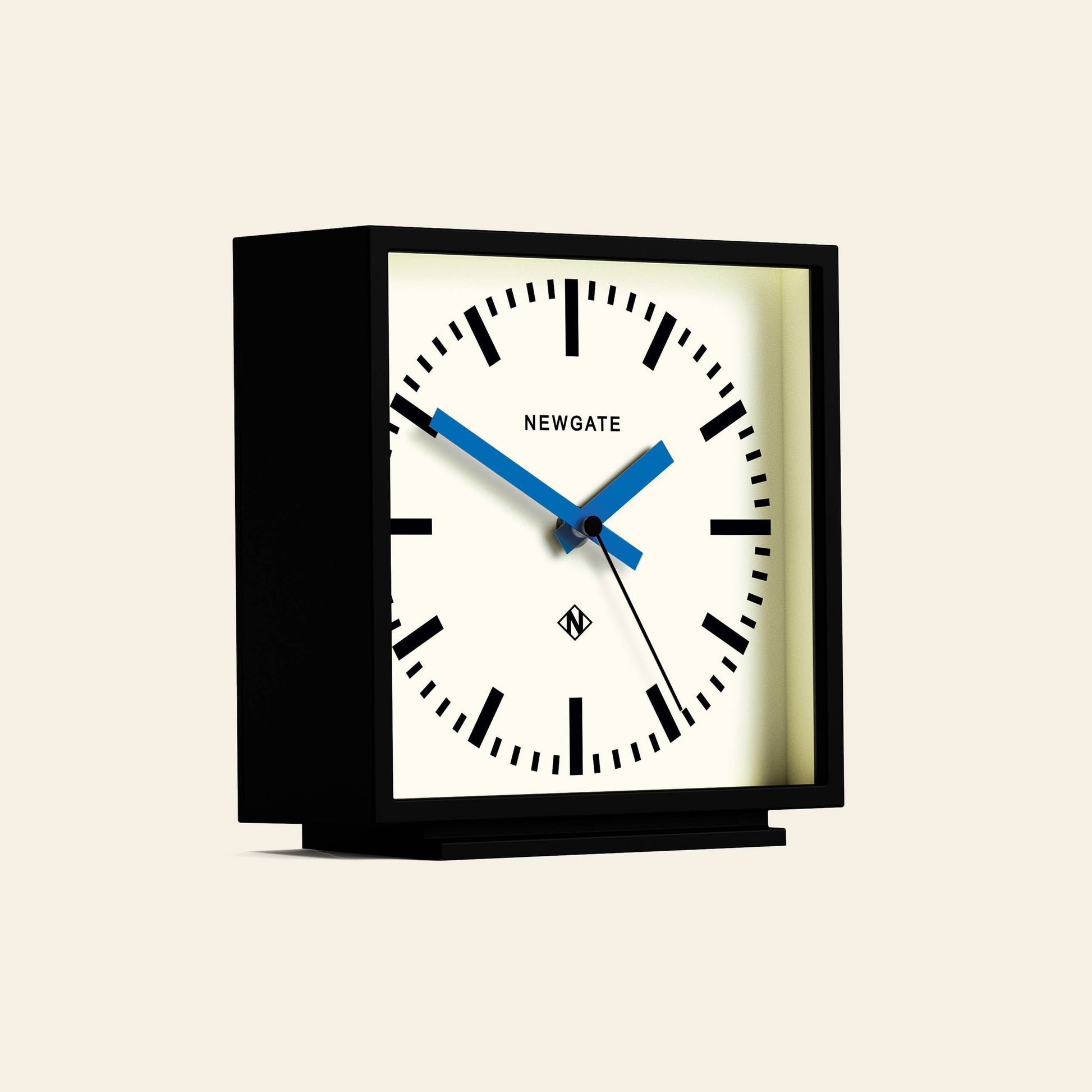 The Newgate Amp Mantel Clock is a modern square black mantel clock with a white face, black hour markers, blue hands showing 10:08, and classic station style. The NEWGATE brand name is printed on the clock face.