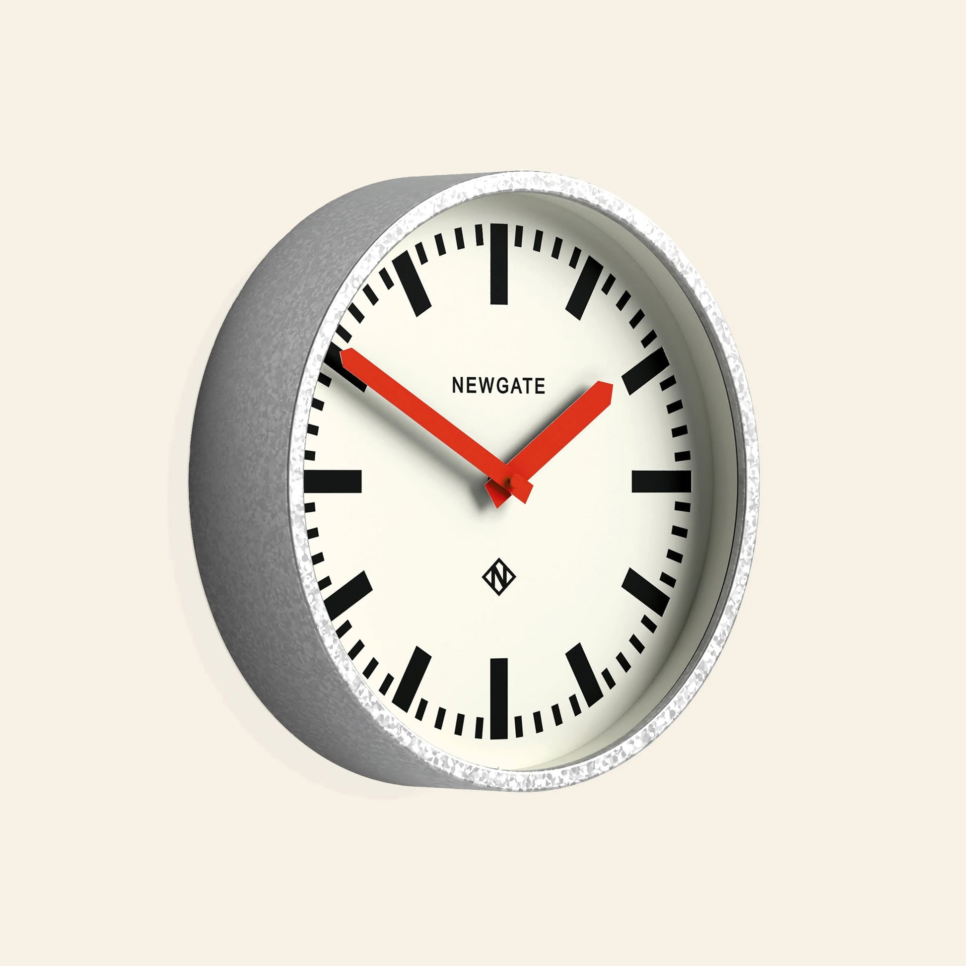 The Newgate Luggage Wall Clock Galvanised features a gray frame, white face, bold black hour markers, and red hands. Inspired by mid-century station clocks, it displays the Newgate logo and shows the time as 10:09.