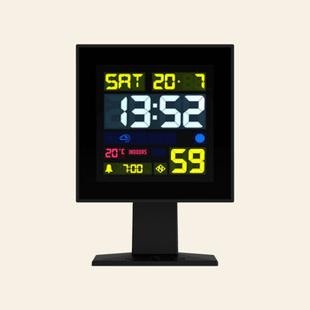 The Newgate Monolith LCD Alarm Clock by Newgate shows 13:52 on Saturday, with indoor temperature at 20°C, humidity at 59%, and icons for weather forecast, moon phase, alarm settings, and other useful info.