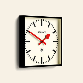 The Newgate Number Five Railway Wall Clock features a white face, black case, bold black markers, vibrant red hands, and the Newgate logo at the top center for classic-meets-modern style.