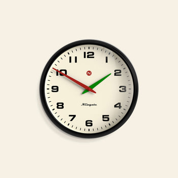 The Newgate Superstore Wall Clock by Newgate features a round black frame, cream-colored face with black numbers, and shows 10:10:39. Its black hour hand, green minute hand, and red second hand create a vintage retro look.