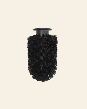 The Normann Copenhagen Ballo Brush Head, featuring dense bristles, stands upright against a plain light background—ideal for contemporary home cleaning.