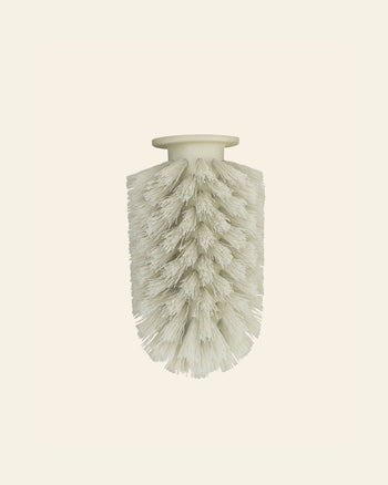 The Normann Copenhagen Ballo Brush Head by Normann Copenhagen features a white cylindrical design with densely packed bristles and a flat, round top, ideal for modern home cleaning, shown isolated on a plain light background.