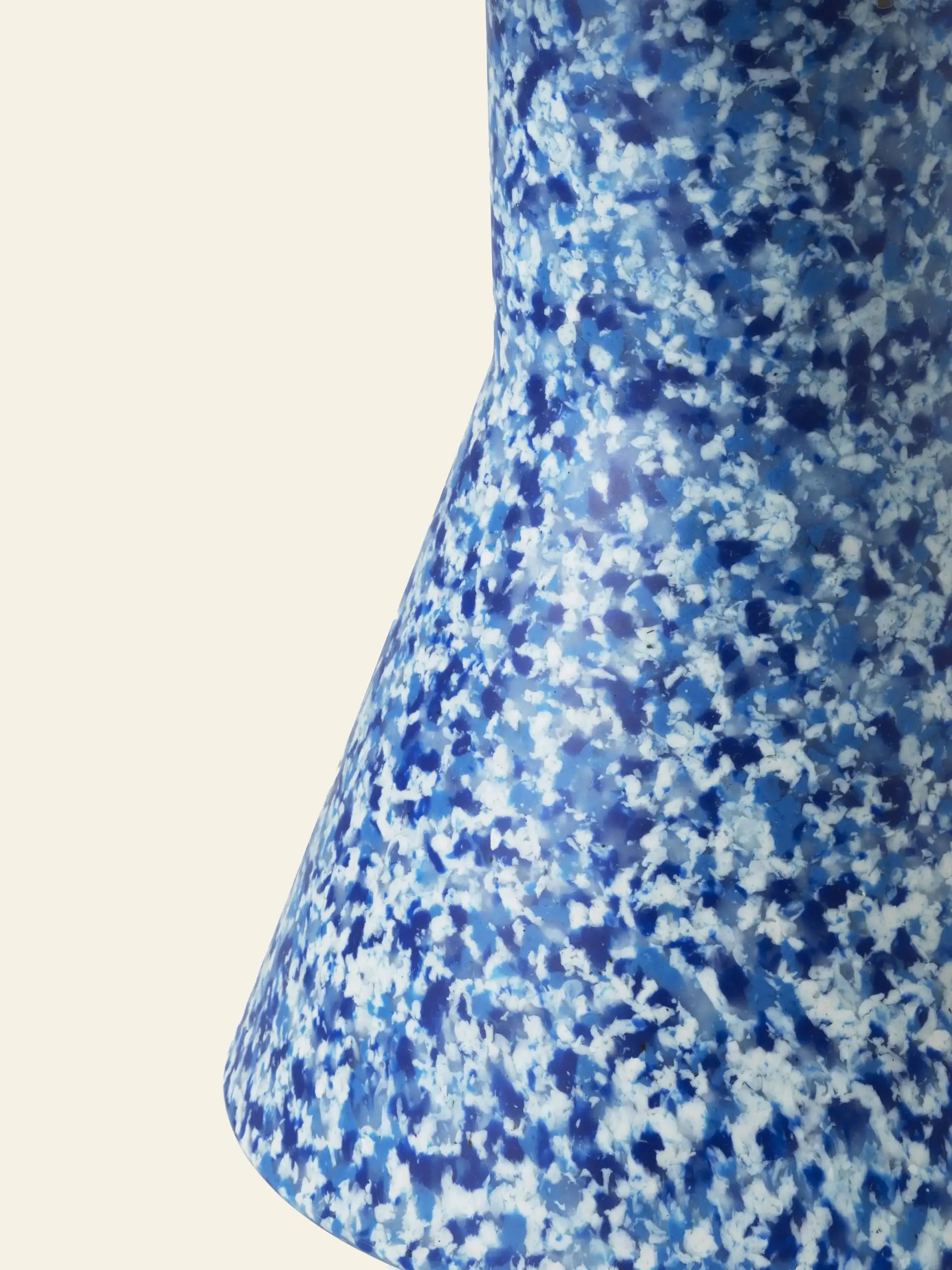 A close-up of the Normann Copenhagen Bit Stool Cone by Normann Copenhagen, featuring a blue and white speckled finish, flared base, and multifunctional design against a plain light background.