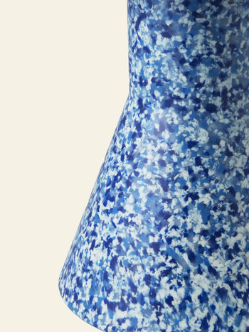 A close-up of the Normann Copenhagen Bit Stool Cone by Normann Copenhagen, featuring a blue and white speckled finish, flared base, and multifunctional design against a plain light background.