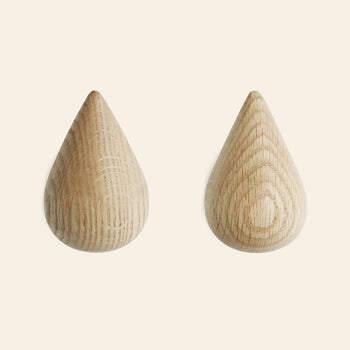 The Normann Copenhagen Dropit Hooks Large, Set of 2, by Normann Copenhagen, feature smooth teardrop shapes and natural wood grain, beautifully displayed side by side on a light, neutral background.