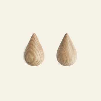 The Normann Copenhagen Dropit Hooks Small, Set of 2, are shown side by side on a light background, highlighting their elegant drop-shaped design in either oak or dark walnut by Normann Copenhagen.