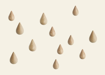 The Normann Copenhagen Dropit Hooks Small, Set of 2 features teardrop-shaped wooden hooks in Oak or dark Walnut, shown arranged in a scattered pattern on a plain, light background.