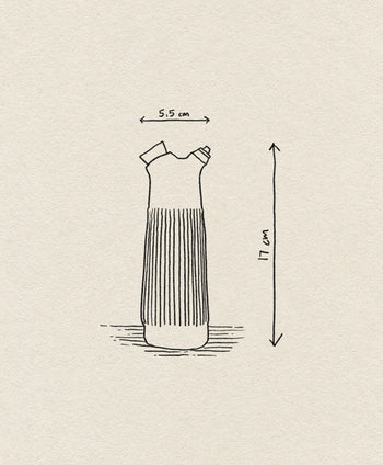 A simple line drawing of the Normann Copenhagen Junto Oil Bottle, featuring a tall, pleated design and narrow neck, labeled with arrows showing its height of 17 cm and top width of 5.5 cm.