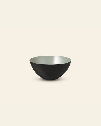 The Normann Copenhagen Krenit Bowl (12.5cm) features Danish minimalist design with a matte black exterior and smooth light gray interior, shown against an off-white background.