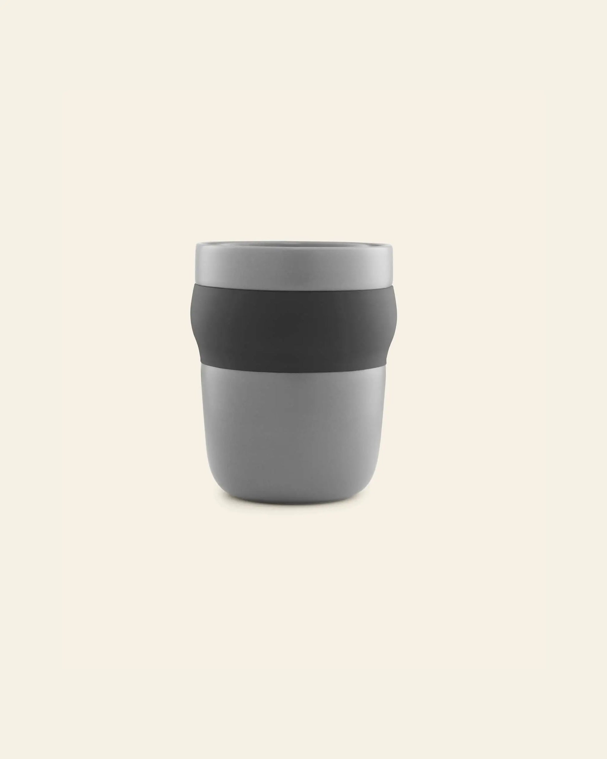The Normann Copenhagen Obi Mug is a minimalist gray porcelain mug with a black band around the middle, displayed against a plain light beige background.