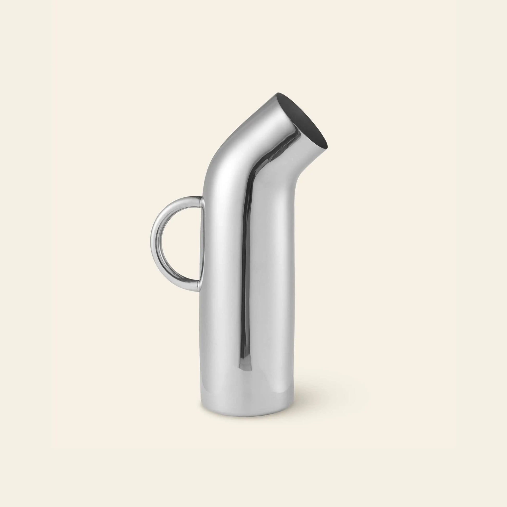 The Normann Copenhagen Pipe Pitcher by Normann Copenhagen features a modern stainless steel design with a curved spout and round handle, adding retro style to any kitchen. Shown against a plain, light beige background.